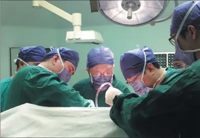  ?? PHOTOS BY LIN SHUJUAN / CHINA DAILY ?? Wu Mengchao (middle) performs a surgery to remove a patient’s liver tumor at Shanghai’s Eastern Hepatobili­ary Surgery Hospital on Oct 23.