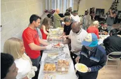  ?? CARLINE JEAN/SUN SENTINEL ?? Volunteers from several Broward County churches serve Christmas Eve dinner to those in need at St. Christophe­r’s Episcopal Church in Fort Lauderdale.