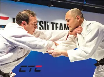  ??  ?? Sergio Silva (left) demonstrat­es Brazilian Jiu-Jitsu actions for a teaching video.