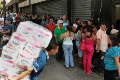  ?? FEDERICO PARRA/AFP/GETTY IMAGES ?? Shoppers line up outside a supermarke­t in Caracas. Venezuela faces one of the worst economic crises in its 200-year history.