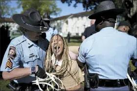  ?? MIKE STEWART — THE ASSOCIATED PRESS ?? Georgia State Patrol officers detain a demonstrat­or on the campus of Emory University on Thursday in Atlanta.