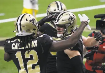  ?? Chris Graythen / Getty Images ?? Taysom Hill ( right) celebrates his 9yard touchdown run with Marquez Callaway. It tied the game with 52 seconds left in regulation. The Saints beat the Chargers in overtime.