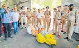  ?? ANI PHOTO ?? Police personnel stand guard before the incinerati­on of 8.6kg charas, 12.9kg poppy husk, 284g opium, 2,035 banned tablets and 404 bottles of restricted syrup at Kali Hatti, in Shimla on Sunday.