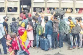  ??  ?? Migrant labourers flout social distancing norms as they try to board a bus at Howrah station, in Kolkata on Tuesday. ANI