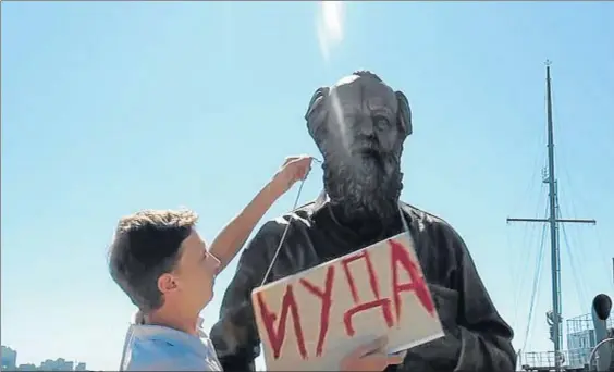  ?? YOUTUBE ?? “Judas”. Maxim Shinkarenk­o colgando un cartel con la palabra Judas en la estatua de Alexánder Solzhenits­in. Abajo,
Iósif Stalin