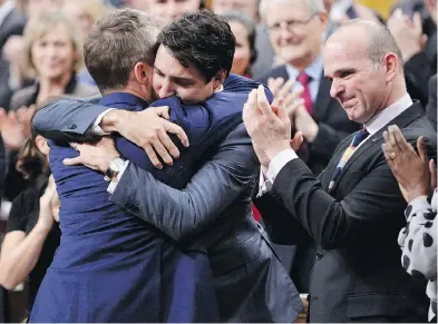  ?? ADRIAN WYLD / THE CANADIAN PRESS ?? Prime Minister Justin Trudeau hugs Veterans Affairs Minister Seamus O’Regan after making a formal apology in the House of Commons to those harmed by federal discrimina­tion against LGBTQ2 people on Tuesday.