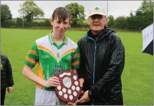  ??  ?? Kilcoole captain Charlie Frawley receives the trophy from referee Peadar De Hora.