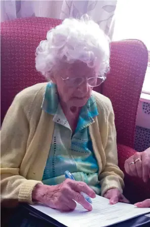  ?? James Clement via The New York Times ?? Dorothy Peel, 108, of London, signs the consent form to participat­e in the supercente­narian study. Even at that age, Peel had a sharp mind and many questions about the study and its use.