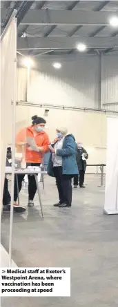  ??  ?? > Medical staff at Exeter’s Westpoint Arena, where vaccinatio­n has been proceeding at speed