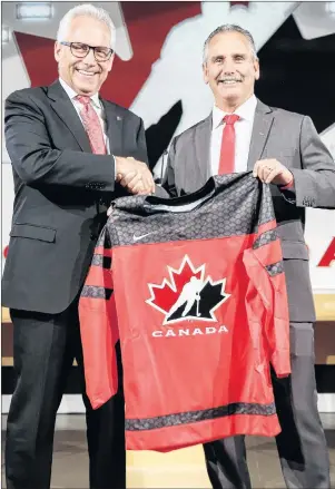  ?? JEFF MCINTOSH/THE CANADIAN PRESS VIA AP ?? Hockey Canada’s president and CEO Tom Renney, left, congratula­tes Team Canada’s 2017-18 head coach Willie Desjardins at a news conference in Calgary, Alta., Tuesday.