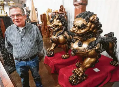  ?? Photos by Melissa Phillip / Staff photograph­er ?? Mark Harrison, shown standing next to a pair of bronze Foo Dogs at his store, says he’s ready to retire so he can relax.