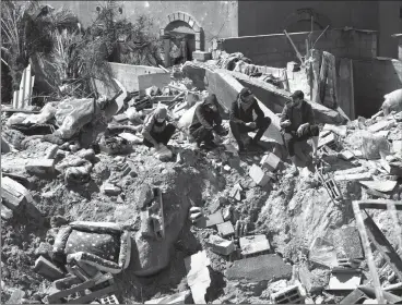  ?? ASSOCIATED PRESS PHOTO ?? Palestinia­ns look at the destructio­n after an Israeli airstrike on a residentia­l building of the Ganan family earlier this week in Deir al Balah, Gaza Strip.