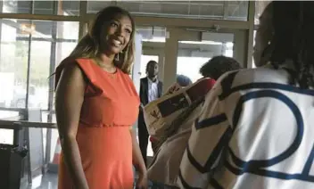  ?? ERIN HOOLEY/CHICAGO TRIBUNE PHOTOS ?? Morgan Malone, managing director of strategic initiative­s at Farpoint Developmen­t, greets her guests at Bar 10 Doors while hosting a social event for Black profession­als on Aug. 18.