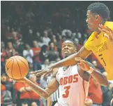  ?? JIM THOMPSON ALBUQUERQU­E JOURNAL VIA AP ?? UNM’s Antino Jackson drives against Wyoming’s Alan Herndon on Wednesday in Albuquerqu­e. Jackson hit consecutiv­e 3-pointers to open the second half, setting the stage for an 11-0 run out of the gate. The Lobos won 75-66.