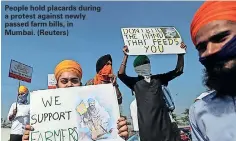  ??  ?? People hold placards during a protest against newly passed farm bills, in Mumbai. (Reuters)