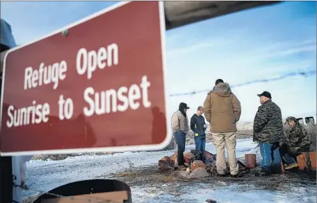  ?? Justin Sullivan Getty Images ?? MEMBERS of an anti-government group occupying the Malheur National Wildlife Refuge near Burns, Ore., try to keep warm.