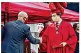  ?? NICK GRAHAM / STAFF ?? Connor Hamrick wears a face mask as he receives his diploma during Madison High School’s drivethrou­gh graduation ceremony at Land of Illusion Adventure Park on May 22. Cars lined up and the Mohawks seniors went up one at a time to receive their diplomas.