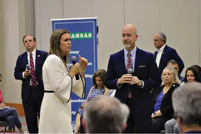  ?? (Caitlan Butler/News-Times) ?? As Arkansas Sec. of Education Jacob Oliva looks on, Gov. Sarah Huckabee Sanders speaks during a town hall meeting held Tuesday evening at the El Dorado Conference Center on the LEARNS Act, her signature education bill.