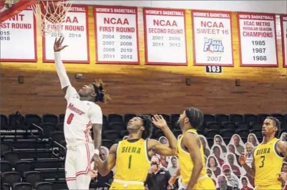  ?? Connor Giblin / Marist Athletics ?? Marist junior guard Raheim Sullivan makes a layup in front of Siena freshman forward Colin Golson (1) during their game on Saturday afternoon at Mccann Arena in Poughkeeps­ie. Sullivan finished with 13 points, four assists and two rebounds in the Red Foxes’ victory.