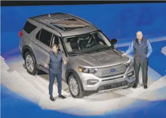  ?? CARLOS OSORIO/AP ?? Ford exec Jim Farley (left) and CEO Jim Hackett stand next to the redesigned 2020 Ford Explorer during its unveiling Wednesday in Detroit. It’s 200 pounds lighter than previous models.