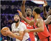  ?? Luis Sinco Los Angeles Times ?? ANTHONY DAVIS, who led the Lakers with 27 points, draws a crowd of Raptors defenders.