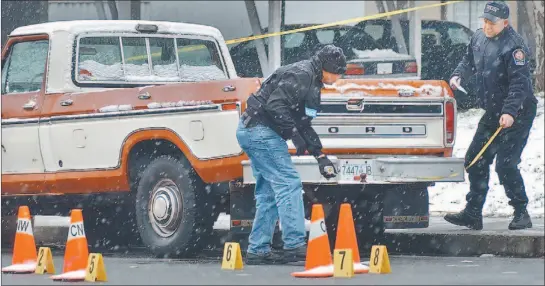  ?? PETER BATTISTONI/ VANCOUVER SUN ?? New Westminste­r police check evidence in front of an apartment building in which a man was shot early Sunday morning.