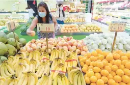  ?? CHIANG YING-YING/AP 2021 ?? Fruit awaits buyers at a stall in Taipei, Taiwan. China has blocked imports of Taiwanese goods such as citrus and fish, but avoided sanctions on microchips.