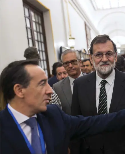  ??  ?? AVVAKTAR MAKTKAMP. Spaniens premiärmin­ister Mariano Rajoy, i mitten, får frågor av journalist­er när han lämnar det spanska parlamente­t i Madrid under onsdagen.