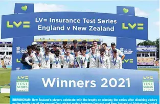  ??  ?? BIRMINGHAM: New Zealand’s players celebrate with the trophy on winning the series after clinching victory on the fourth day of the second Test cricket match between England and New Zealand at Edgbaston Cricket Ground yesterday. —AFP