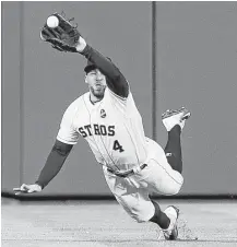  ?? Brett Coomer / Houston Chronicle ?? Astros center fielder George Springer makes a diving catch in the fifth inning on Justin Taylor’s line drive to stifle a Dodgers rally.