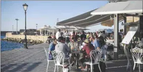  ??  ?? People enjoy an outside terrace in the old town of Chania (La Canee) on the island of Crete, yesterday.