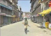  ?? WASEEM ANDRABI/HT ?? A soldier patrols a closed market in Srinagar. The Valley has been shut down to protest against the 35A hearing.