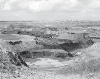  ??  ?? A portion of the Shell Albian Sands oilsands mine is seen from an overlook near Fort McMurray, Alta. Canadian Natural plans to spend $12.74 billion in cash and shares to acquire the assets.