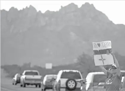  ?? JOSH BACHMAN /THE LAS CRUCES SUN-NEWS VIA AP ?? Triny Rivera and other supporters of the Organ Mountains-Desert Peaks National Monument protest from the New Mexico Farm and Ranch Heritage Museum during U.S. Interior Secretary Ryan Zinke’s visit in July.