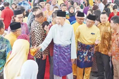  ??  ?? JUHAR (tengah) diiringi Rahman ketika tiba di majlis rumah terbuka itu.