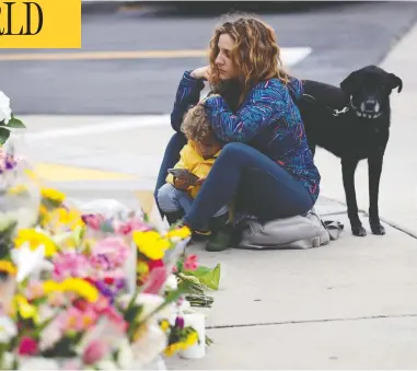  ?? GREG BULL / THE ASSOCIATED PRESS ?? Ali De Leon pauses at a memorial with her son Leo across the street from the Chabad of Poway in Poway, Calif., on Monday. A gunman opened fire in the synagogue on Saturday, killing one congregant and wounding three others.