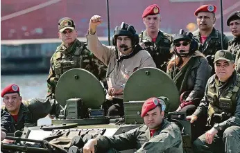  ?? FOTO REUTERS ?? Mezi svými – jak dlouho ještě? Venezuelsk­ý prezident Nicolás Maduro (uprostřed v helmě) s manželkou Ciliou Floresovou (po Madurově levici) na armádním vozidle během vojenské přehlídky v pobřežním městě Puerto Cabello.