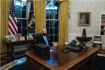  ??  ?? President Joe Biden signs a series of executive orders in the Oval Office of the White House, Wednesday, Jan. 20, 2021, in Washington. (AP Photo/Evan Vucci)