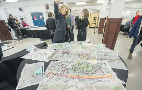  ?? ARLEN REDEKOP ?? People examine concept drawings after Lon LaClaire, Director of Transporta­tion, lead an unveiling of the Arbutus Greenway concept at Point Grey Secondary on Sunday.