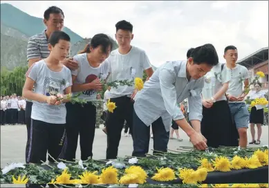  ?? HUA XIAOFENG / FOR CHINA DAILY ?? Family members of people who died in the recent Jiuzhaigou earthquake pay tribute to their loved ones in Jiuzhaigou county, Sichuan province, on Tuesday. About 1,000 people participat­ed in the memorial service. According to Chinese tradition, the...