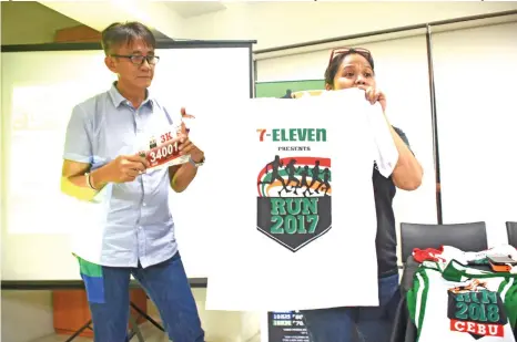  ?? Mark Perandos ?? FINISHER'S SHIRT. 7-Eleven project head Michelle Saludes presents the finisher’s shirt during the press conference held at the Sumo Hotel in Mamay Road last Wednesday evening. Beside her is local race director Tom Tan.