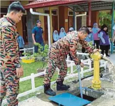  ??  ?? ANGGOTA bomba memeriksa pili bomba untuk memastikan dalam keadaan baik di Pusat Daerah Mengundi, di Kota Belud.