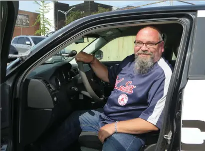  ??  ?? Above, Finland native Kari Lehtonen sits in a police cruiser during his visit to the Woonsocket Police Station. Below, Lehtonen, left, and Woonsocket Police Chief Thomas Oates show off a cruiser, similar to the one Lehtonen will have shipped to Finland.