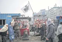  ?? AFP ?? A flag of the Islamic Emirate of Afghanista­n is displayed at a meat shop in a market in Kabul.