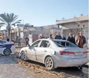  ?? (AFP) ?? People check the site of an airstrike which killed at least two civilians, in the town of Zawiya, 45km west of Tripoli on Thursday