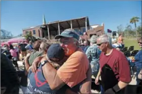  ?? AP PHOTO/GERALD HERBERT ?? Jerry Register, a congregati­on member of St. Andrew United Methodist Church, hugs a fellow church member during Sunday service, outside the damaged church in the aftermath of Hurricane Michael in Panama City, Fla., Sunday, Oct. 14, 2018.