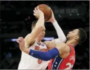 ?? SETH WENIG — THE ASSOCIATED PRESS ?? Knicks’ Kristaps Porzingis, left, tries to move past 76ers’ Ben Simmons during New York’s loss to Philadelph­ia.