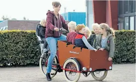  ??  ?? Bakfiets – der Klassiker aus den Niederland­en gilt als die Familienku­tsche schlechthi­n. Bis zu sechs Kinder passen in die Kiste, die nach Belieben mit Sitzpölste­rn und Regendach aufgemotzt werden kann.