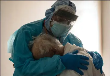  ??  ?? Dr Joseph Varon comforts a patient in the Covid-19 intensive care unit in Houston. Texas has now reached over 1.2m cases