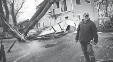  ?? DAX MELMER ?? Larry Greco, vice-president of the Marentette Beach Associatio­n, survey the damage done to homes along the eastern shore near Point Pelee after a strong weekend storm. Greco estimates his property received $10,000-to-$15,000 damage.